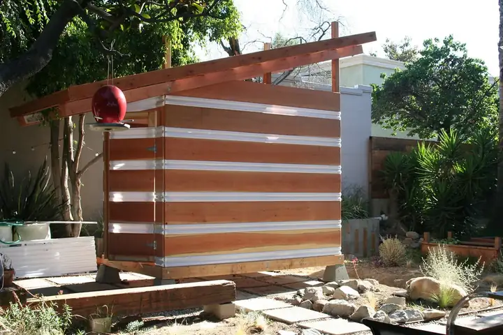 Abri de jardin en bois à toit une pente, bardage horizontal en lames de bois, posé sur une terrasse