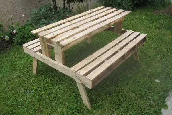 Table de pique-nique fabriquée en bois de palette, posée sur la pelouse