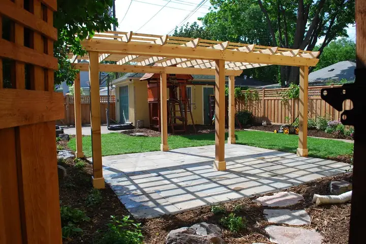 Pergola en bois à quatre poteaux au-dessus d'une terrasse dallée