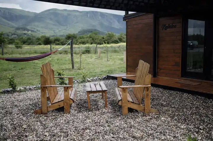 Deux fauteuils Adirondack en bois et une petite table basse posés sur du gravier