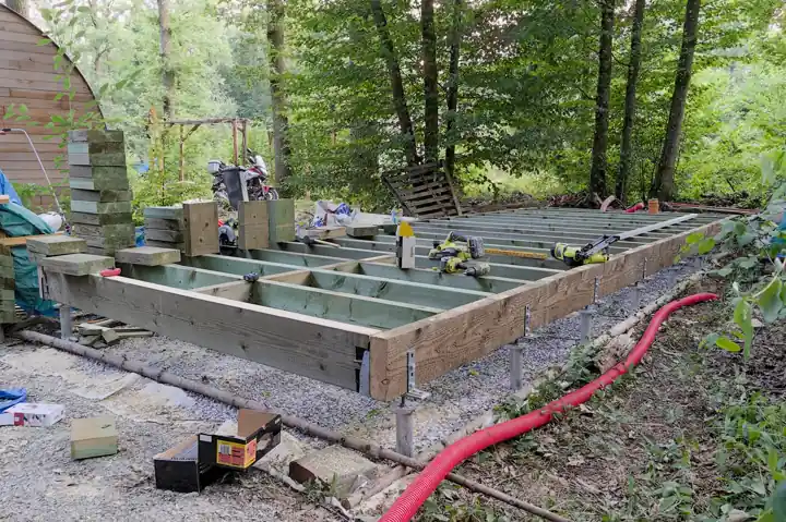 Cadre de plancher en bois résineux, longrines et solives, posé au-dessus du sol sur un chantier